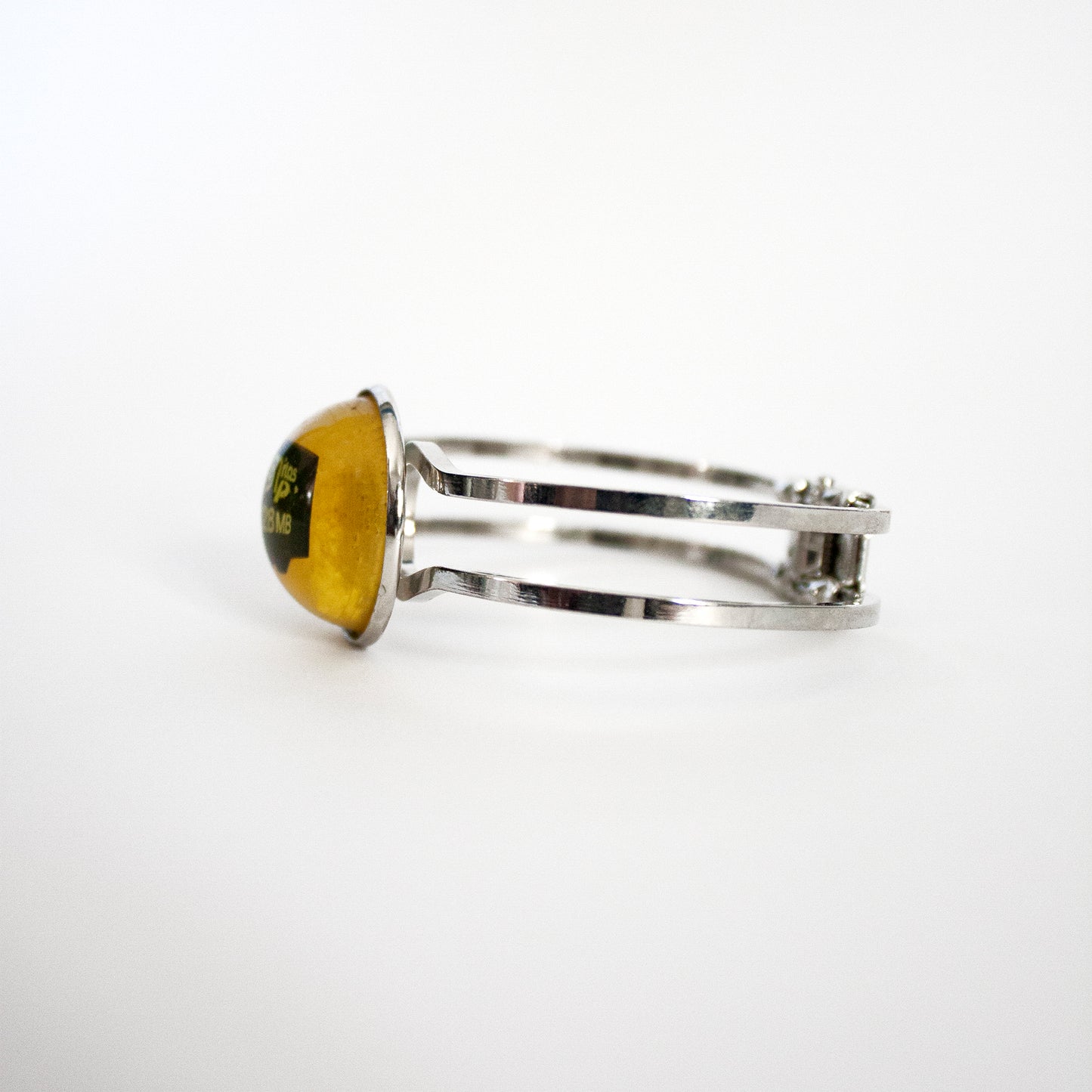 琥珀色の樹脂でできたメモリ カードとファイルが入ったブレスレット。(開けないでください!)