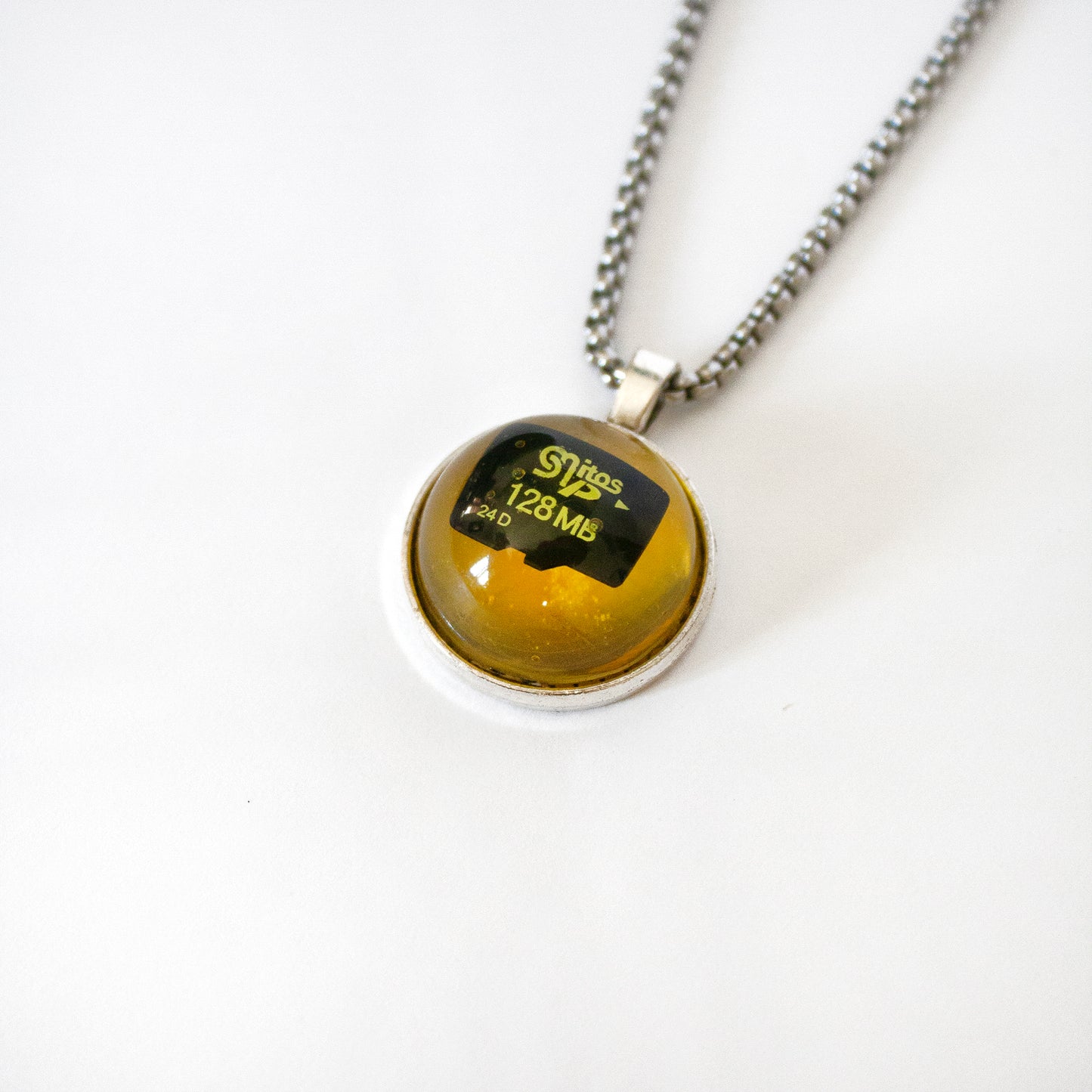 PENDANT WITH A MEMORY CARD AND FILE IN AMBER RESIN. (DO NOT OPEN!)