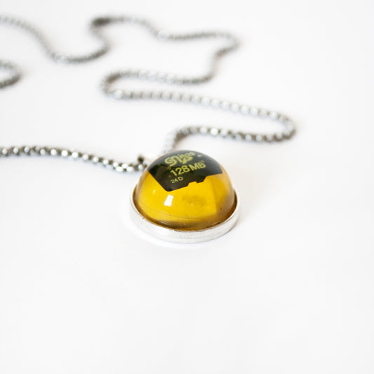 PENDANT WITH A MEMORY CARD AND FILE IN AMBER RESIN. (DO NOT OPEN!)