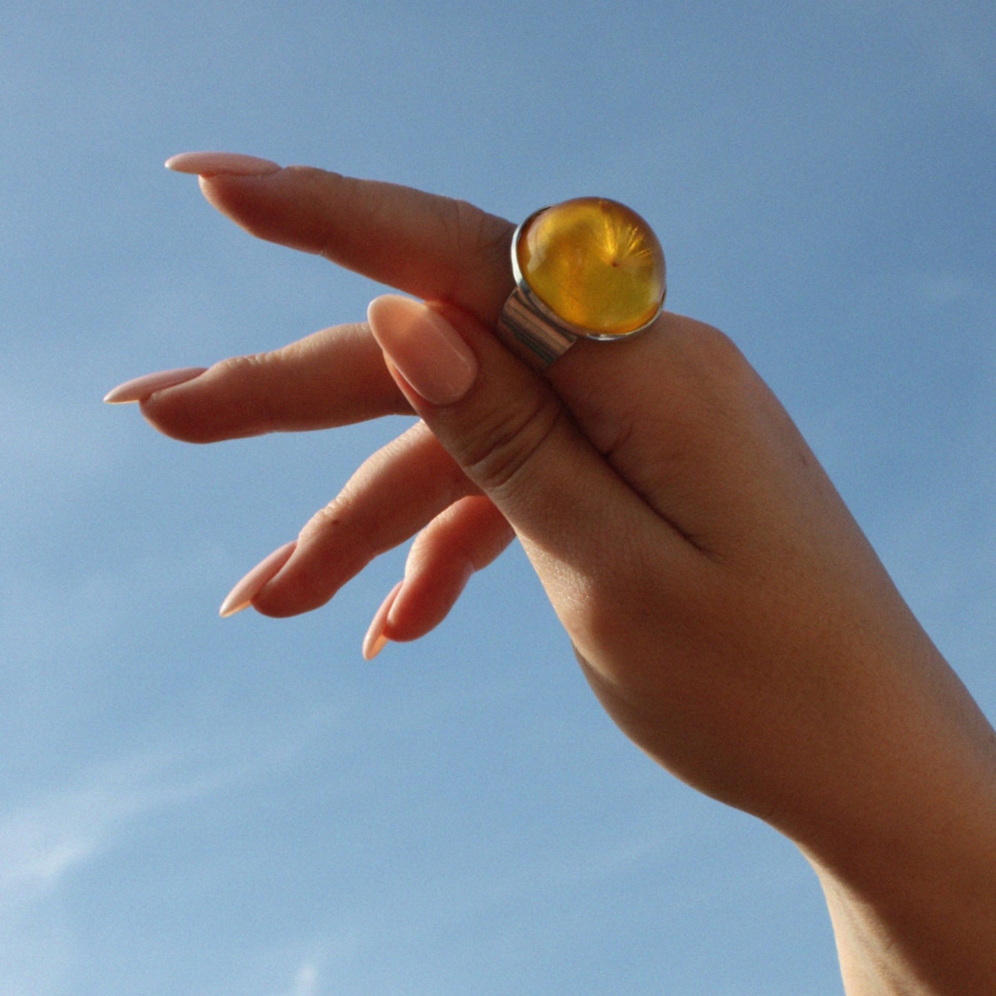 RING WITH A FLYING SEED INSIDE AMBER RESIN.