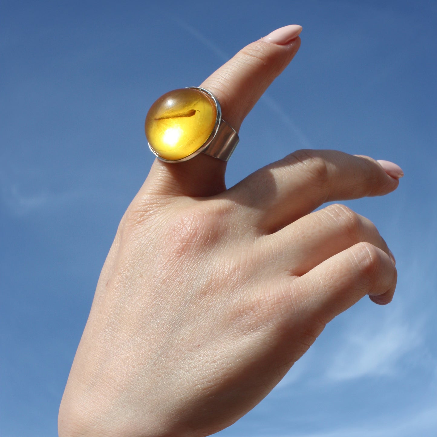 RING WITH A FLYING SEED INSIDE AMBER RESIN.