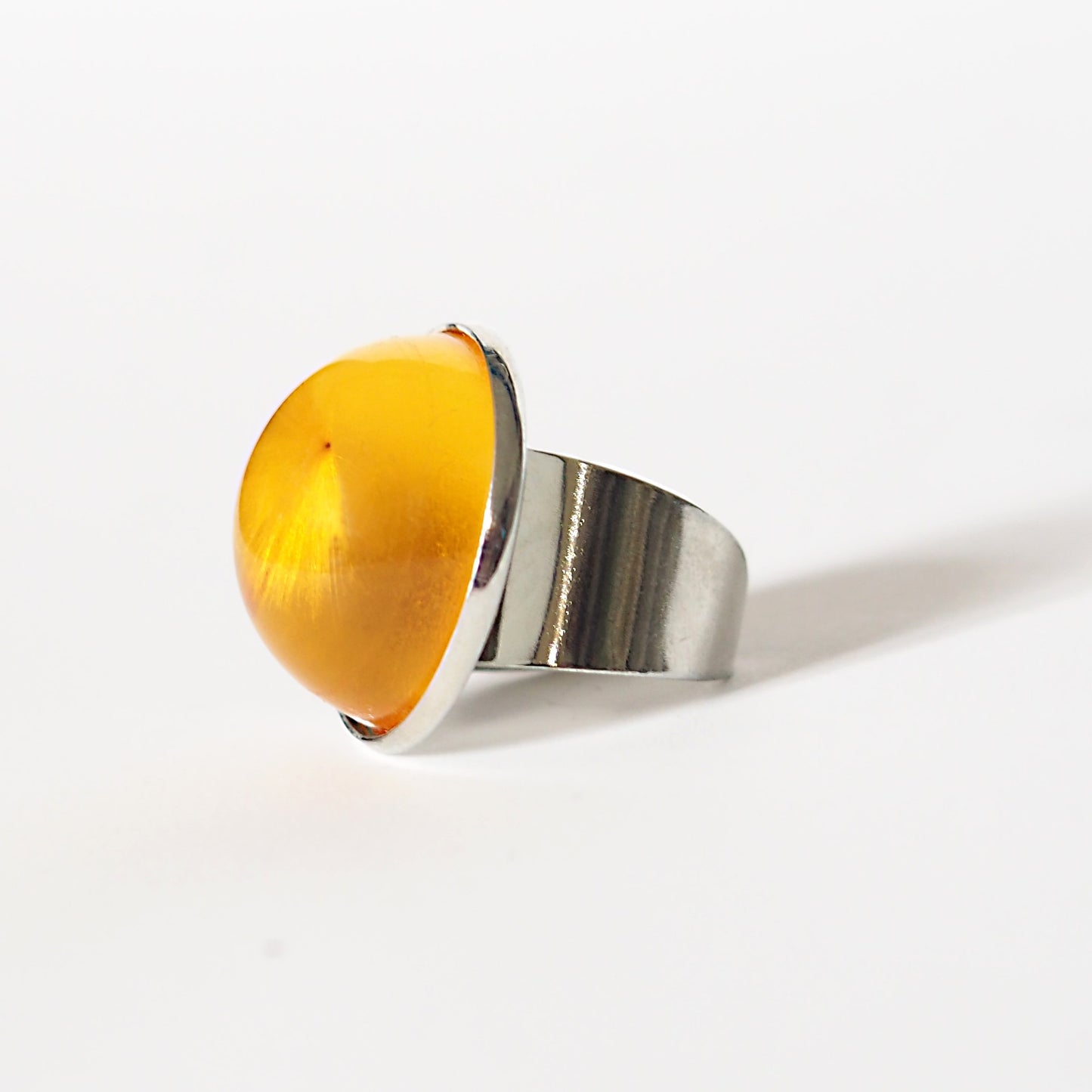 RING WITH A FLYING SEED INSIDE AMBER RESIN.
