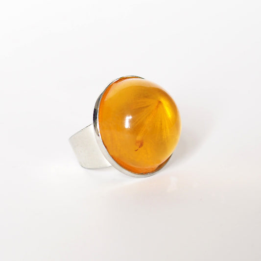RING WITH A FLYING SEED INSIDE AMBER RESIN.