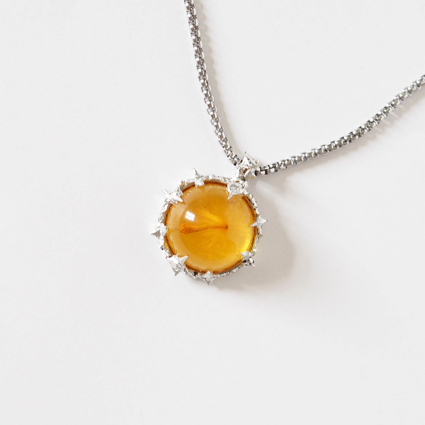 PENDANT WITH A SEED IN AMBER RESIN (HAND-CRAFTED).