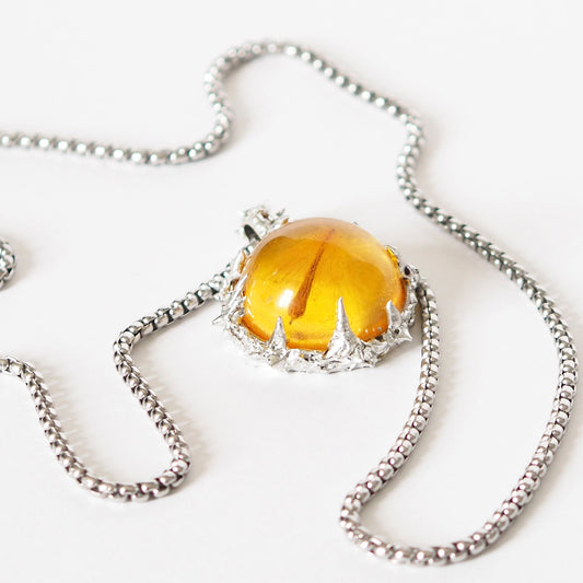 PENDANT WITH A SEED IN AMBER RESIN (HAND-CRAFTED).